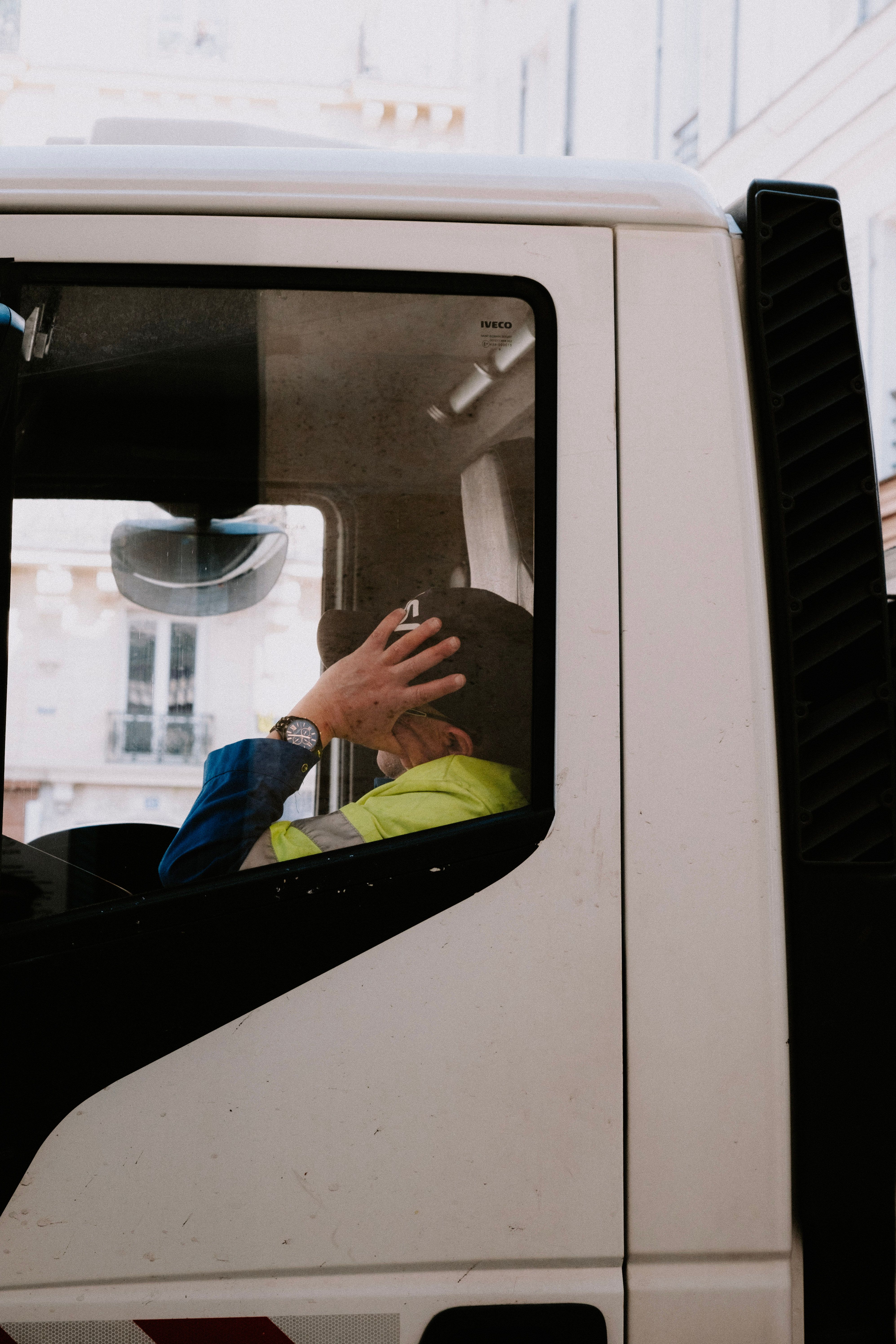 Truck driver resting inside the cabin of a parked semi-truck during a rest break
