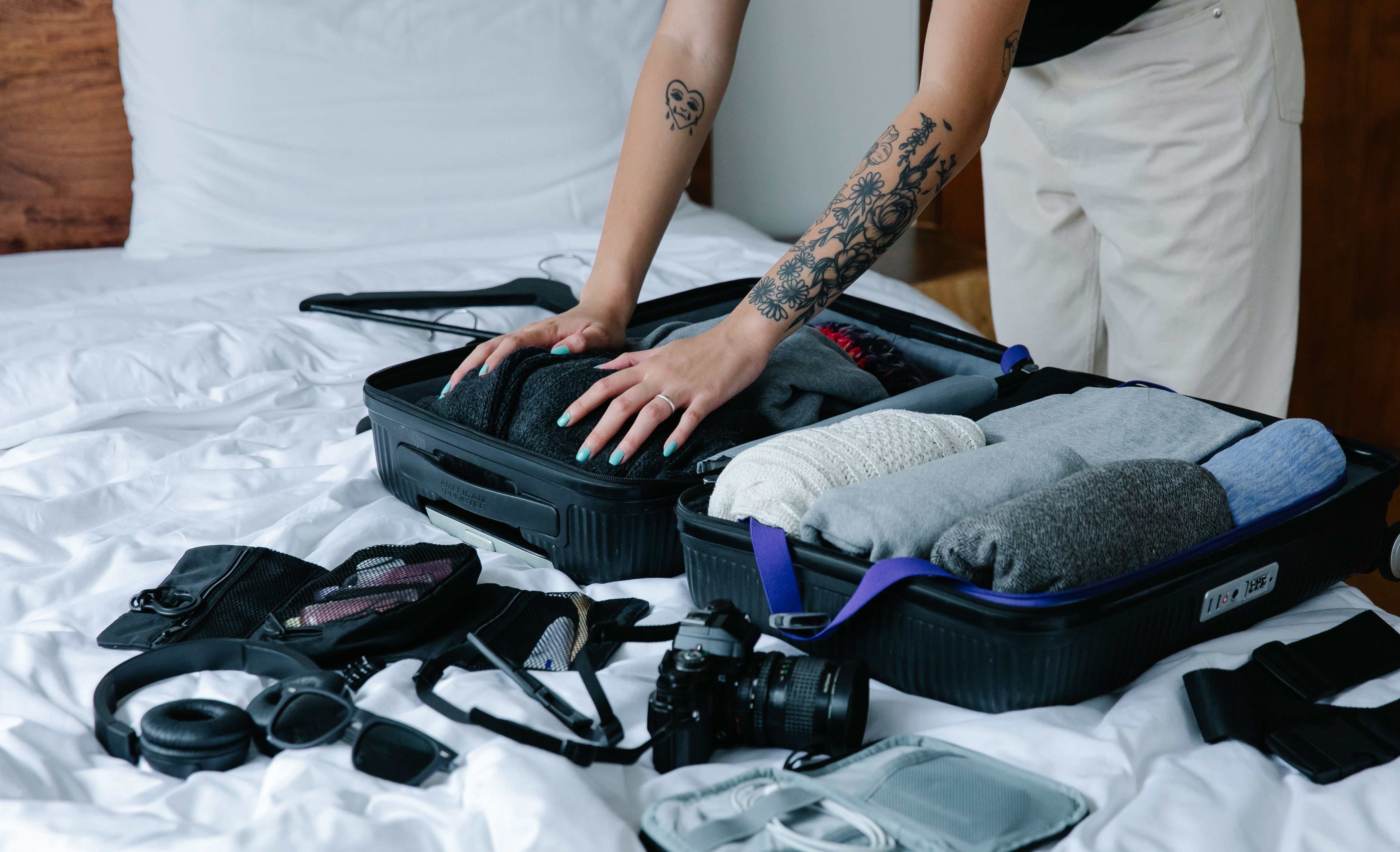 Woman packing a suitcase on a bed while preparing for a business trip
