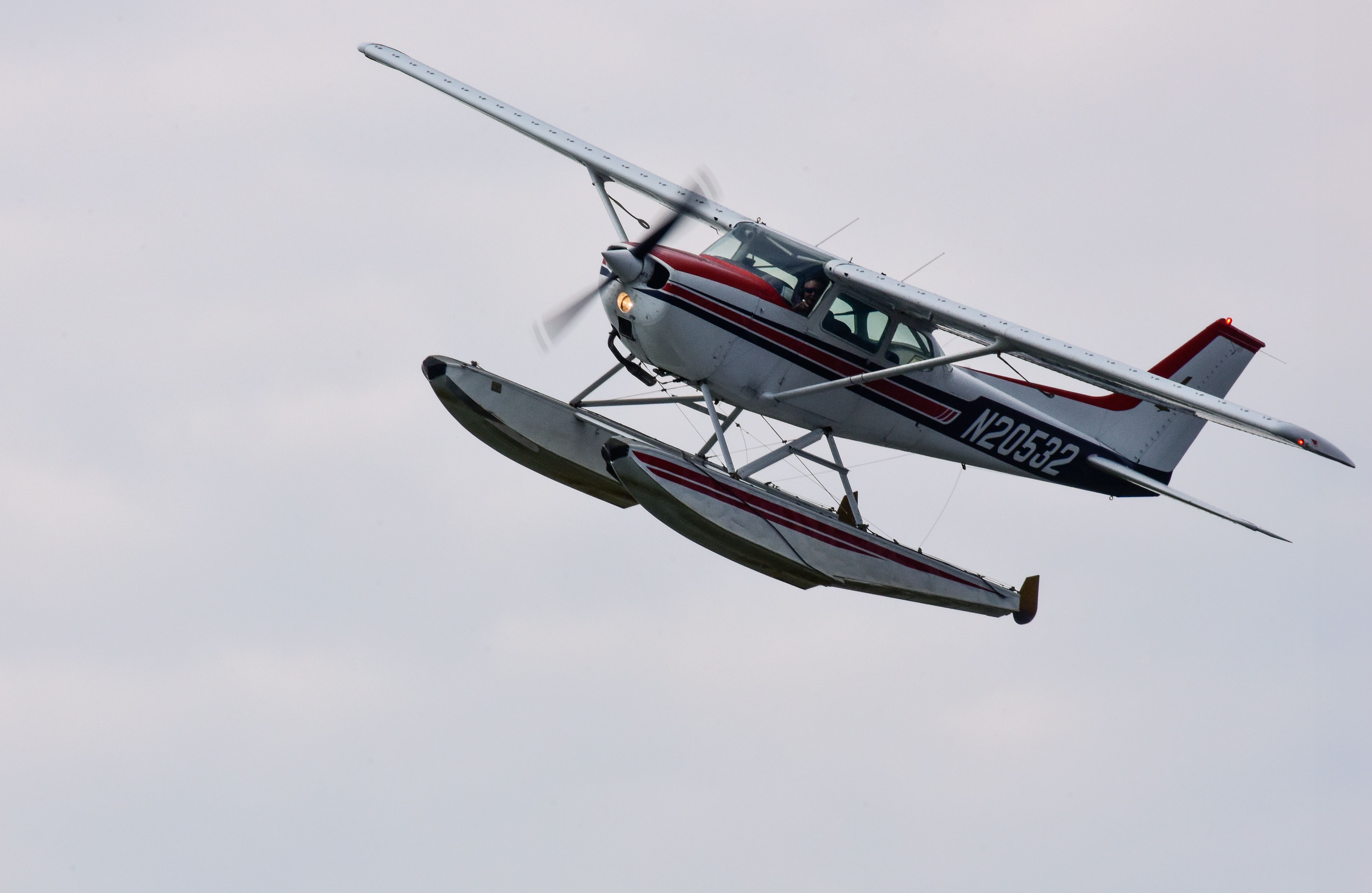 Floatplane flying above Grand Rapids, Minnesota, with clouds behind it.