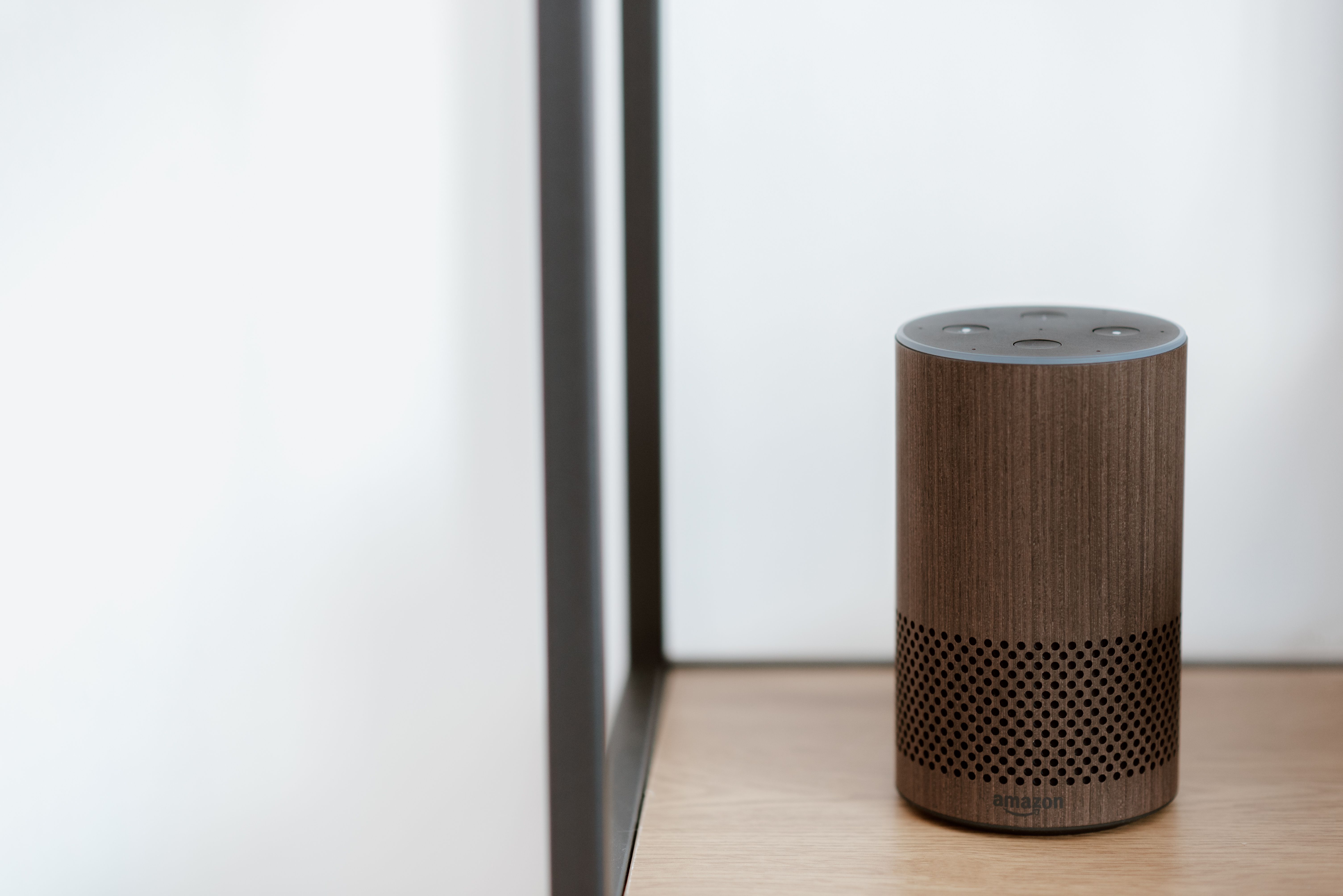 Minimalist smart speaker on a shelf in a calm modern room