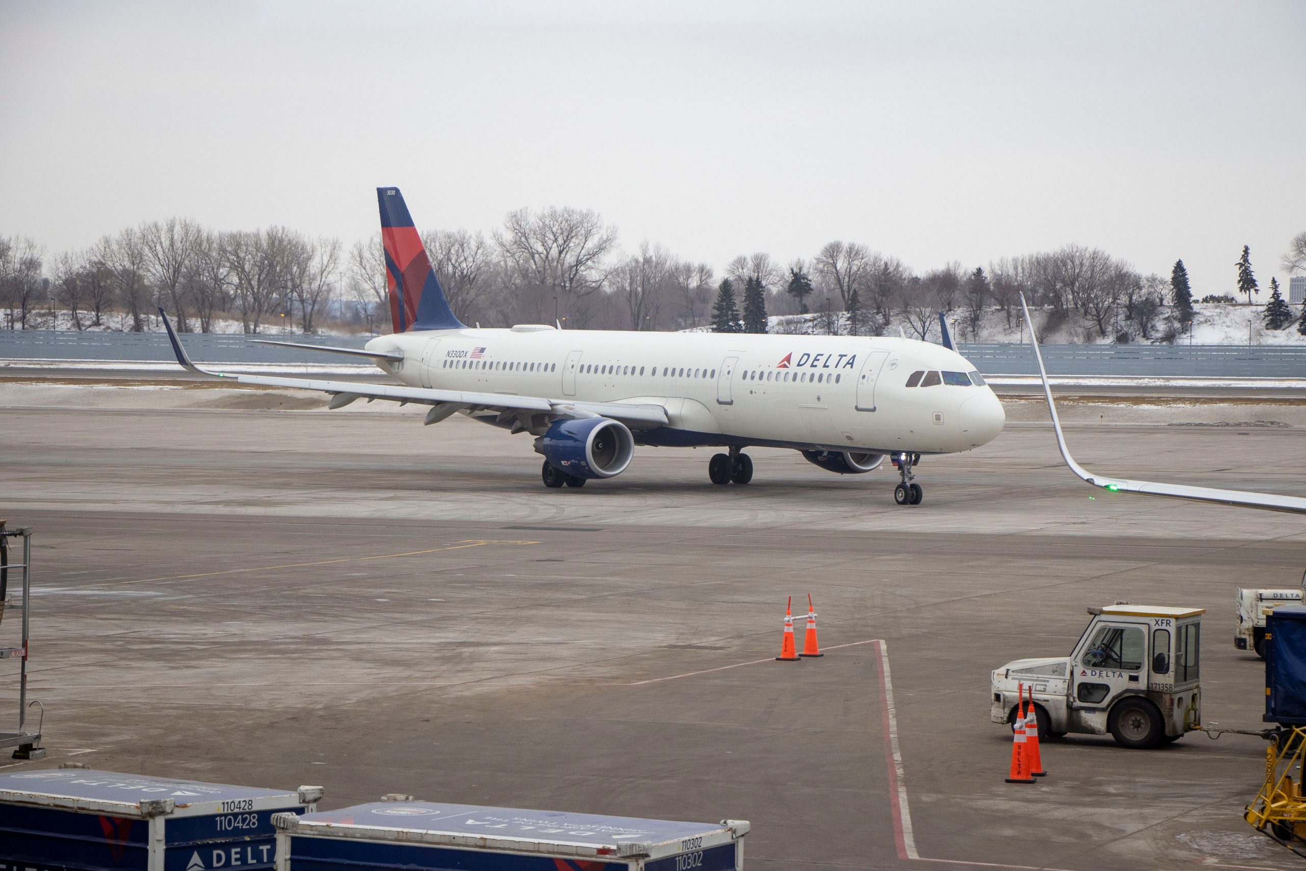 Delta passenger airplane preparing for departure at a snowy Minnesota airport, illustrating winter air travel in the North.