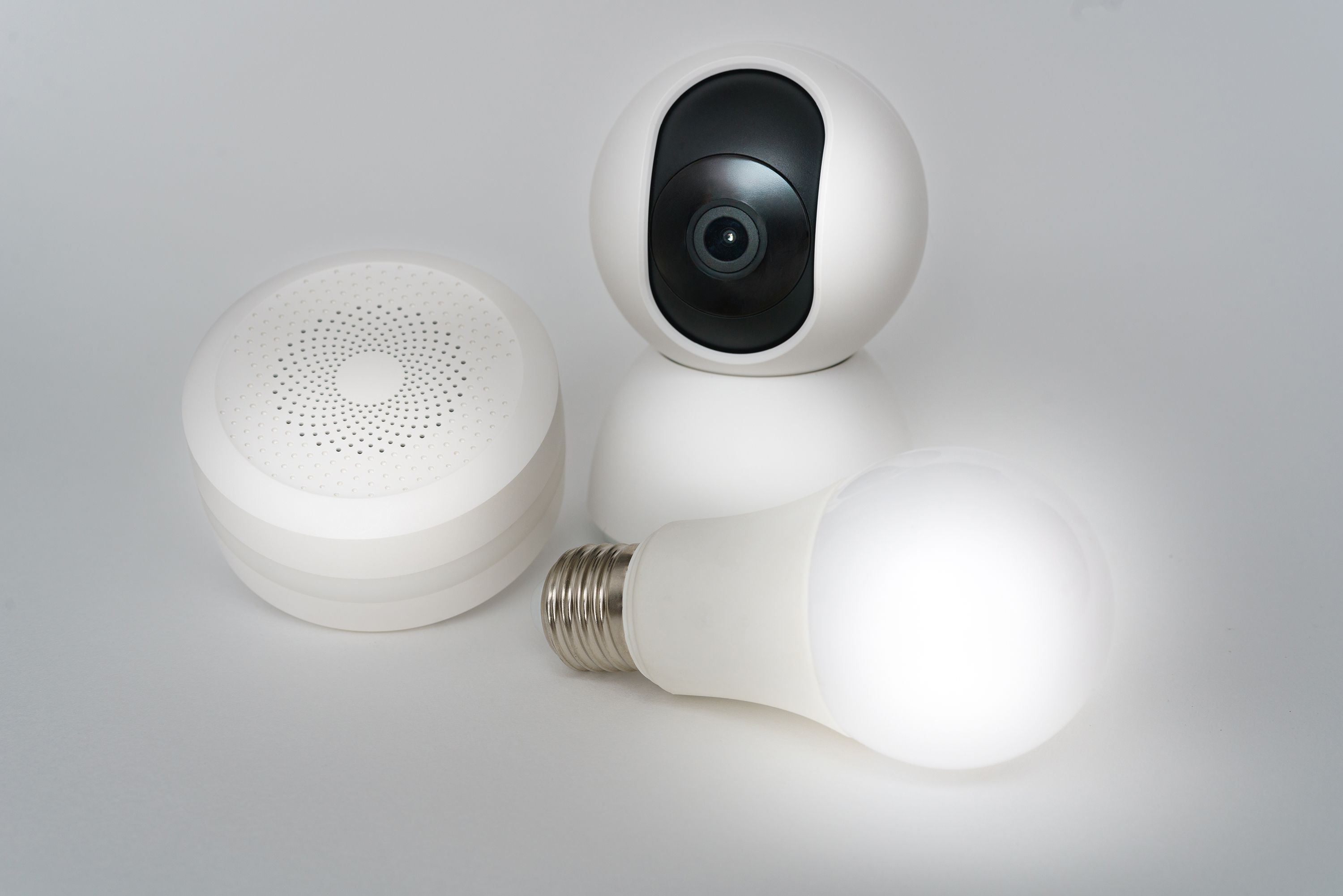 Multiple smart home devices including a camera, speaker, and lightbulb arranged together
